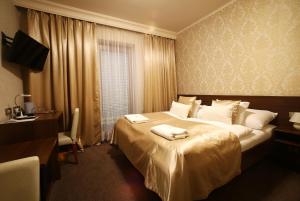 a hotel room with a large bed with towels on it at Hotel Roudna in Plzeň