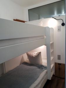 a white bunk bed with a pillow and a lamp at Vanoise C in La Daille
