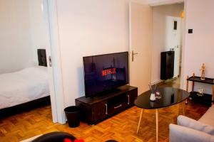 a living room with a television and a bed at Thessaloniki Center Apartment On The Sea in Thessaloniki