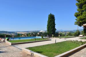 a park with a swimming pool and a tree at Villa Fonti in Orciano di Pesaro