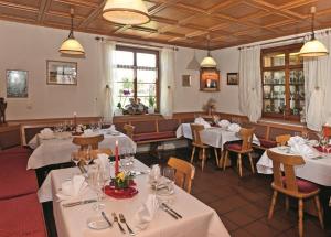 uma sala de jantar com mesas e cadeiras brancas em Hotel Landgasthof Kranz em Hüfingen