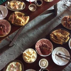 a table full of different types of food on plates at Lux bungalow in Foča