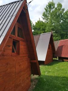 a barn with a door open next to two other buildings at Lux bungalow in Foča