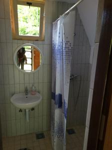 a bathroom with a sink and a shower with a mirror at Lux bungalow in Foča +6 photos