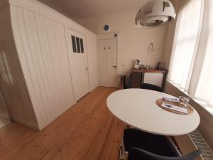 una habitación con una mesa y sillas blancas y una puerta en Bickersbed, en Ámsterdam