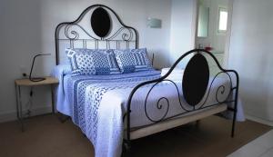 ein Bett mit einer blauen und weißen Decke und Kissen in der Unterkunft ÀNCORA VELLA in Sant Antoni de Calonge