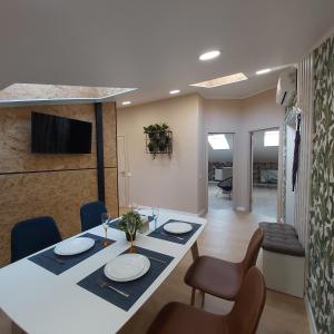 ein Esszimmer mit einem Tisch, Stühlen und einem TV in der Unterkunft Two-Bedroom Apartment near Forum Lviv in Lwiw
