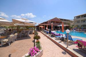 un complexe avec une piscine, des tables et des chaises dans l'établissement Socrates Hotel, à Sidari
