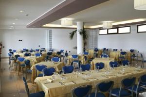 una habitación llena de mesas y sillas con sillas azules en Hotel Miralago en Piediluco