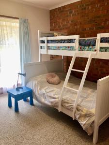 a bedroom with two bunk beds and a blue stool at Beltie Park Homestead in Wangaratta