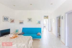 un soggiorno con divano blu e tavolo di Stella Marina - Porto Pirrone Paradise Beach a Leporano