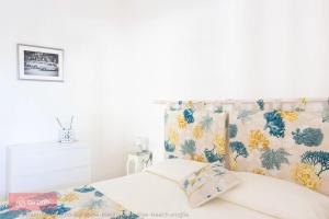 una camera con letto con testiera floreale di Stella Marina - Porto Pirrone Paradise Beach a Leporano