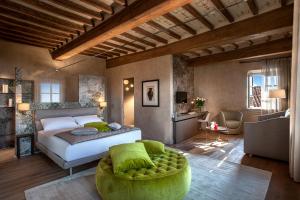 a bedroom with a bed and a green ottoman at Il Cortile di San Michele in Guarene