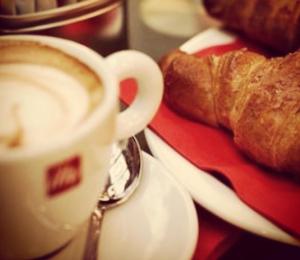 a cup of coffee next to a plate of bread at Seabed superior rooms in Termoli