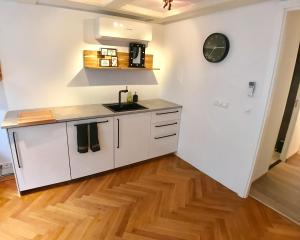 a kitchen with white cabinets and a wooden floor at Heerengracht Penthouse Apartment in Amsterdam