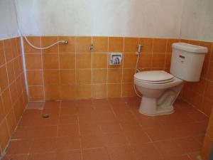 an orange tiled bathroom with a toilet and a shower at Malibu Beach Bungalows in Chaloklum