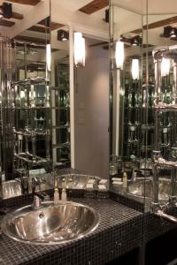 a bathroom with a sink and a large mirror at Boutique Hotel de la Place des Vosges in Paris