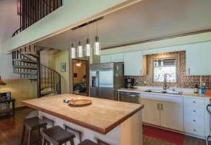 a kitchen with a wooden island in the middle at KOA 3L in Kihei