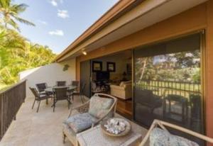 a patio with a table and chairs on a balcony at KOA 3L in Kihei