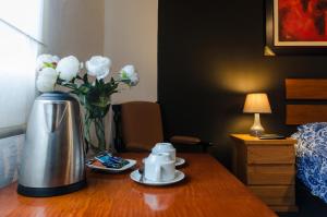 um quarto de hotel com uma mesa com um vaso de flores em Jose Luis Hostal Boutique em Lima