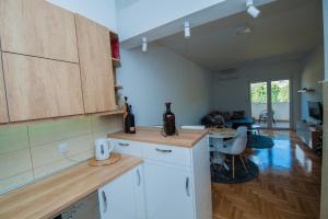 a kitchen with white cabinets and a dining room at Cozy Apartment SINN in Trebinje +11 photos