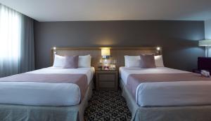 墨西哥城的住宿－皇冠假日酒店－墨西哥城北部塔蘭潘特拉，酒店客房设有两张床和窗户。