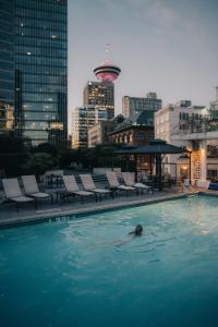 a swimming pool with a large swimming pool in the middle of a city at Fairmont Waterfront in Vancouver