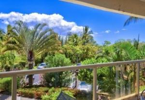 a balcony with a view of a palm tree at Maui Banyan G203a in Wailea