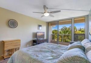 a bedroom with a bed and a ceiling fan at Maui Banyan G203a in Wailea