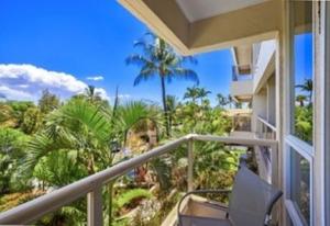 un balcone con una sedia e una vista sulle palme di Maui Banyan G203 a Wailea