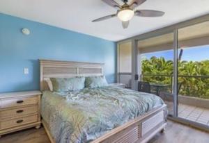 una camera da letto con un letto, una televisione e un balcone di Maui Banyan G203 a Wailea