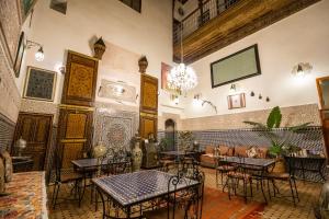 a restaurant with tables and chairs in a room at Riad Dar Tahri in Fès