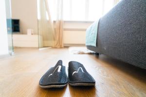 a pair of slippers on the floor next to a couch at Vienna Residence, City Park - Belvedere in Vienna