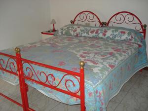 a bedroom with a bed with a floral bedspread at Bed & Breakfast Ciancaleoni in Rivotorto