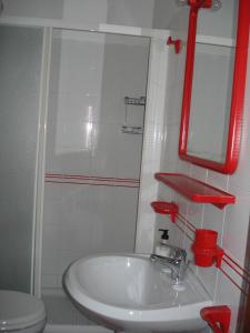 baño con lavabo blanco y espejo rojo en Bed & Breakfast Ciancaleoni, en Rivotorto