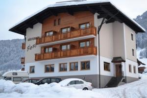 a large building with a balcony in the snow at Gästehaus Sonja in Niederau