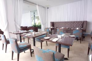 ein Esszimmer mit Tischen und blauen Stühlen in der Unterkunft Radisson San Isidro Hotel & Suites in Lima