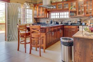 a kitchen with wooden cabinets and a table and chairs at Casa de Cahal Pech in San Ignacio