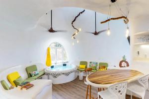 a room with a table and chairs and a tub at Seahorse @ Swan Villas in Placencia Village