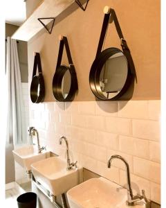 een badkamer met twee wastafels en twee spiegels aan de muur bij Imagina Hostel in Sao Paulo