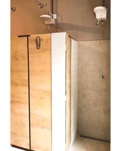 a shower stall with a door in a bathroom at Imagina Hostel in Sao Paulo