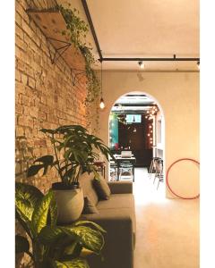 a living room with a couch and a brick wall at Imagina Hostel in Sao Paulo