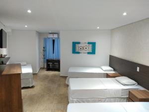 ein Hotelzimmer mit 2 Betten und einem Schreibtisch in der Unterkunft Hotel Paddock in São Paulo