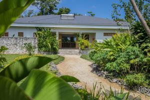 a house with a pathway leading to the front door at Nakatumble - Luxury Sustainable Villa with Farm in Pangona