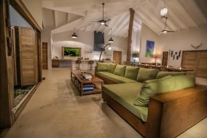 uma sala de estar com um sofá verde e uma mesa em Nakatumble - Luxury Sustainable Villa with Farm em Pangona