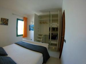 Dormitorio pequeño con cama y armario en Magmamia en Puerto del Carmen