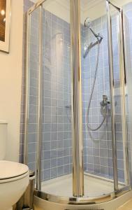 a bathroom with a shower with blue tiles at La Ballena del Charco in Arrecife