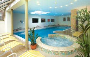 una gran piscina en una casa con sillas en Hotel Ortler, en Ultimo