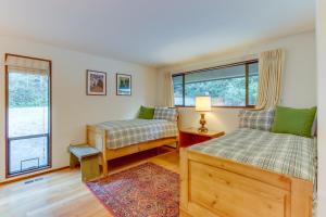 Sleeping Raven Woodland Retreat في بورت انجيليس: غرفة نوم بسريرين ونافذة
