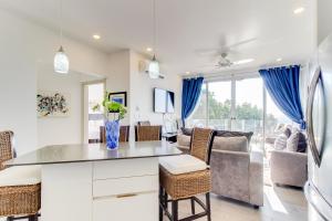 een keuken en een woonkamer met blauwe gordijnen bij Sunset Blvd 402 in Jacó